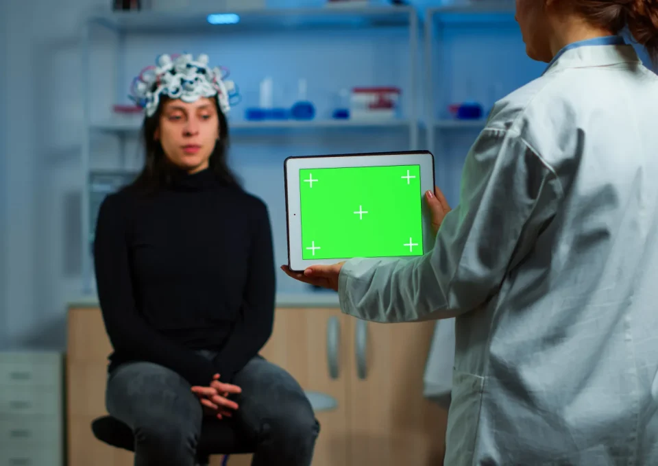 neurologist-doctor-holding-tablet-with-green-screen-neurological-research-laboratory-scientist-using-mockup-chroma-key-display-isolated-desktop-while-patient-with-eeg-headset-wating-background.jpg