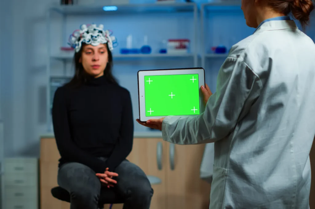 neurologist-doctor-holding-tablet-with-green-screen-neurological-research-laboratory-scientist-using-mockup-chroma-key-display-isolated-desktop-while-patient-with-eeg-headset-wating-background.jpg